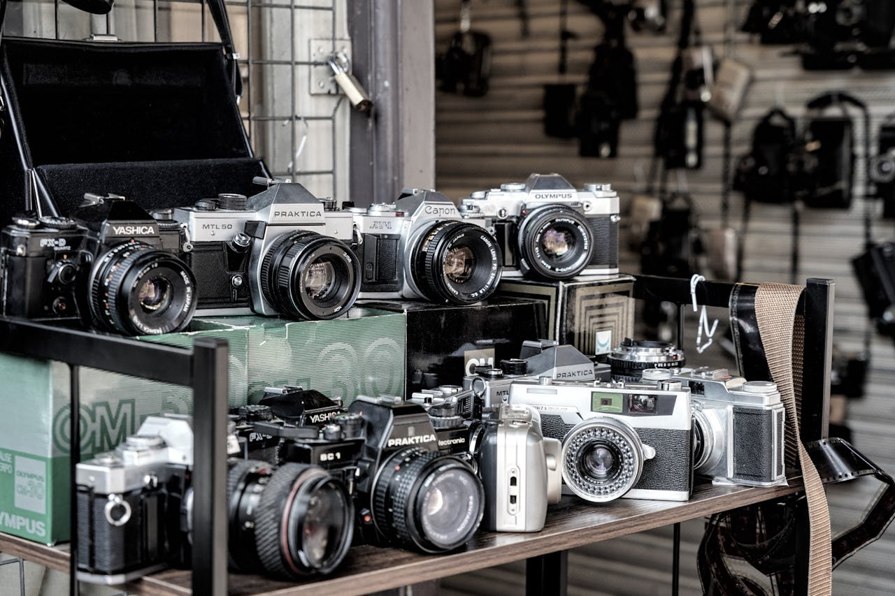 A collection of vintage film cameras on display at a camera shop, capturing the essence of nostalgia and retro photography.